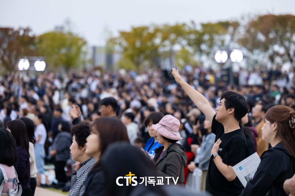 한 손을 들고 예배하는 청년
